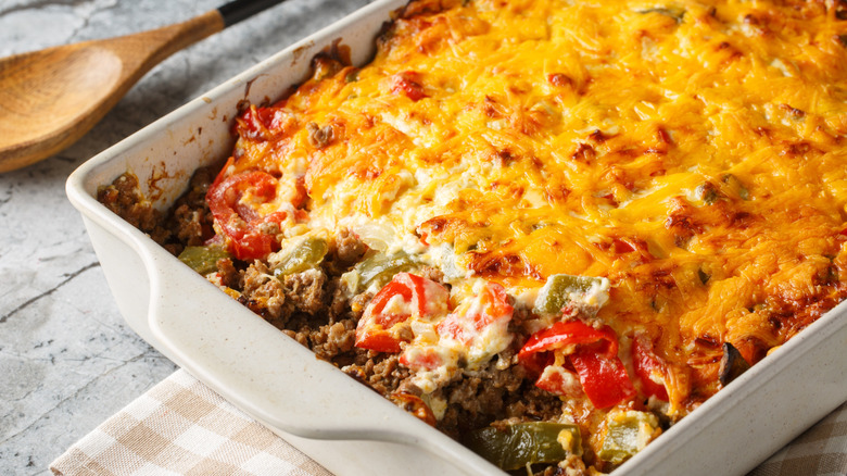 A close up of a John Wayne casserole that's been dug into in a white casserole dish.
