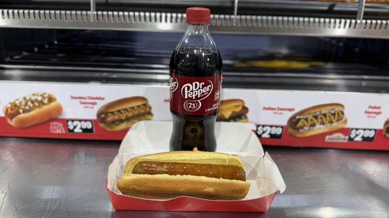 A bottle of Dr Pepper and a Johnsonville Dr Pepper Inspired Sausage in a bun