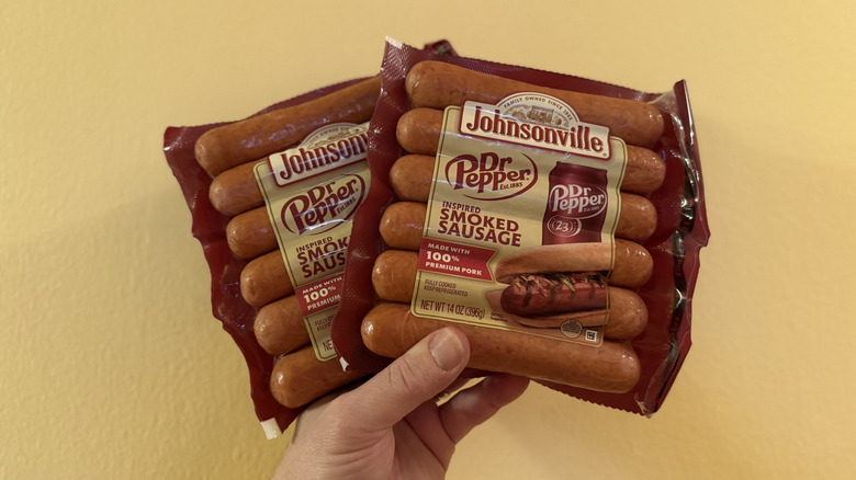 Two packs of Johnsonville Dr Pepper Inspired Sausage held in the air