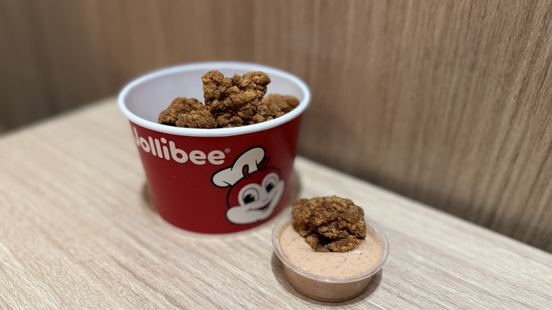 Chicken Nuggets in a cup and one dipped in sauce