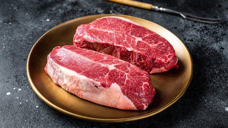 two raw steaks on a plate