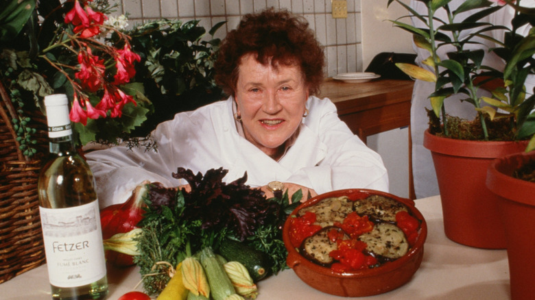 Julia Child posing with vegetables and food