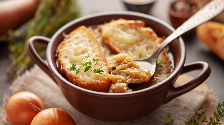 Brown bowl of french onion soup with spoon