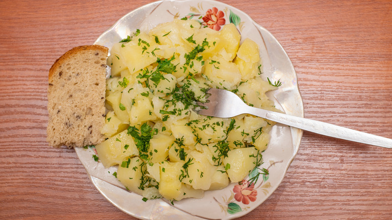 pommes de terre a l'huile on a white plate with a slice of bread