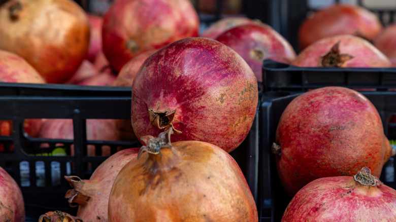 Closeup of pomegranates in black crates