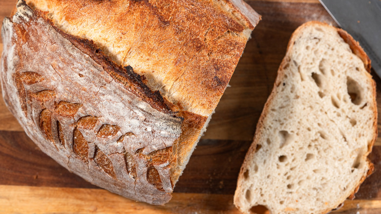 A loaf of fresh sourdough bread with a slice cut out