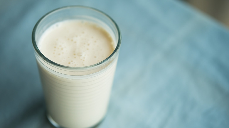 glass of kefir on table with blue tablecloth