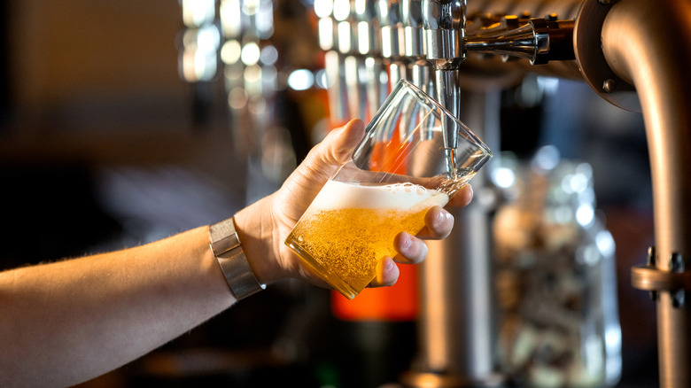 A person pouring a pint in a pub.