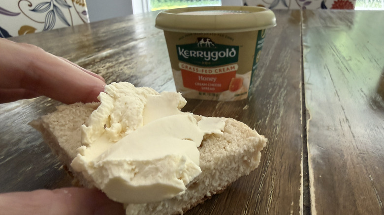 Kerrygold honey cream cheese on a bagel with container in background