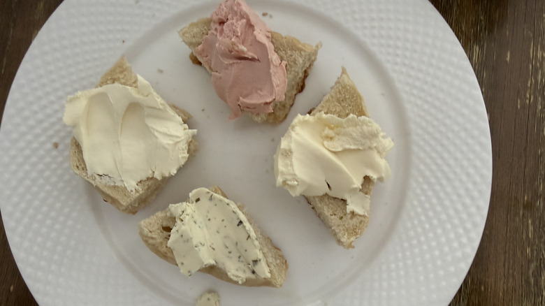 Bagel pieces with all four Kerrygold cream cheeses on a white plate