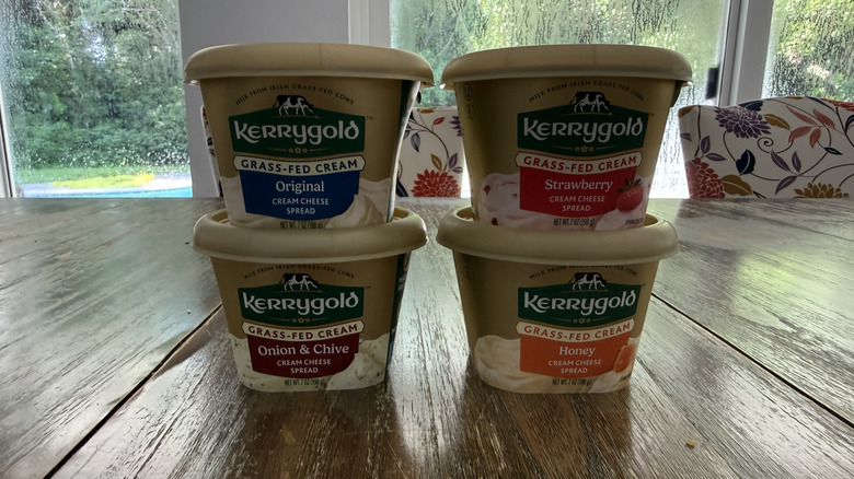 Four Kerrygold cream cheeses on wooden table