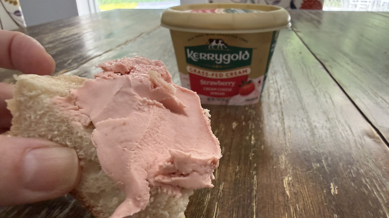 Kerrygold strawberry cream cheese on a bagel with container in background