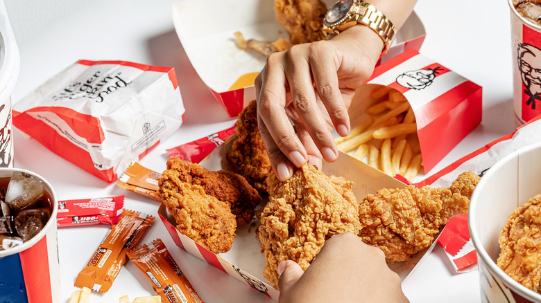 Two people claiming a piece of KFC chicken with a spread
