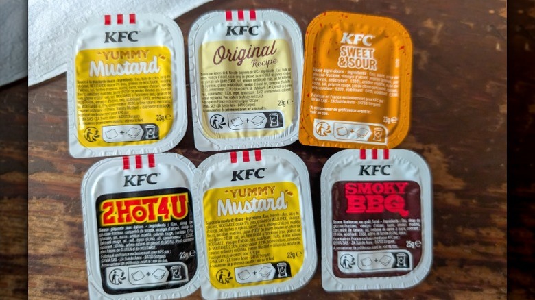A selection of KFC sauces in their dipping packets lined up next to each other.