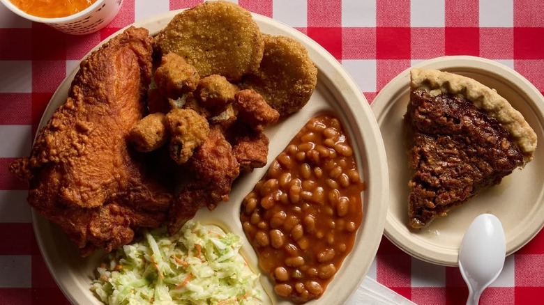 Gus's fried chicken with side dishes and slice of pecan pie