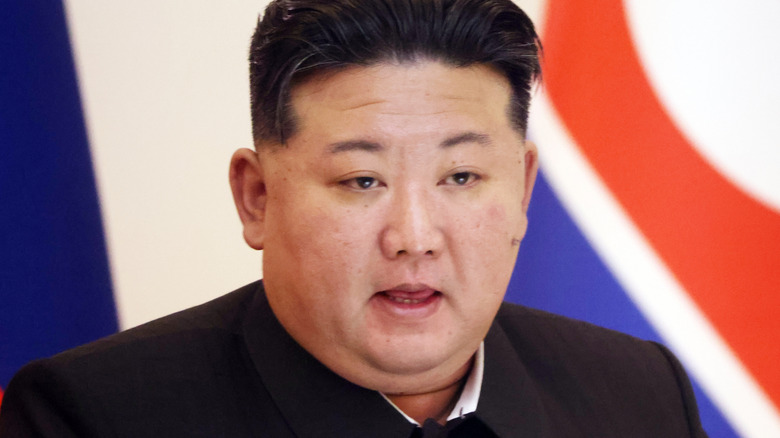 North Korean leader Kim Jong-Un in front of flag