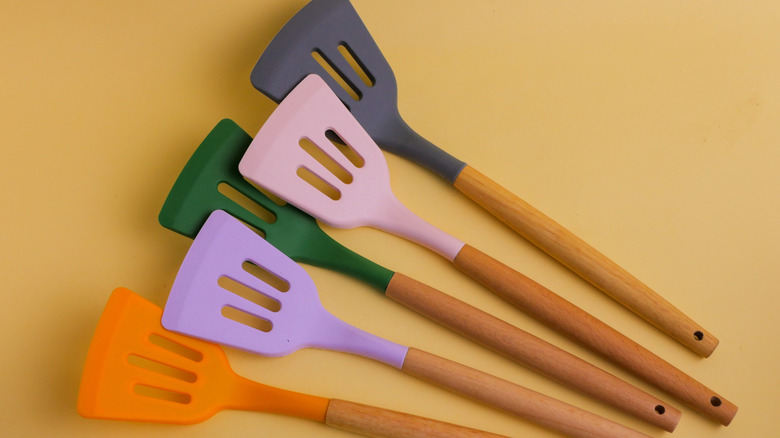 Five colorful silicone spatulas with wooden handles