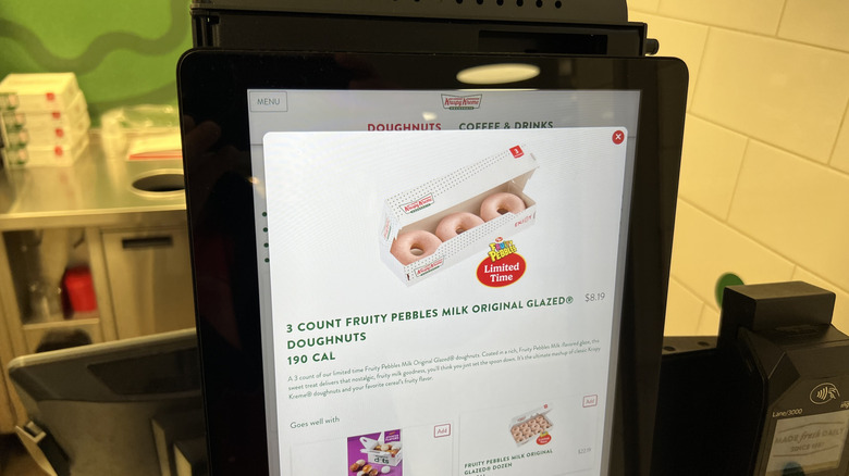 ordering Krispy Kreme's Fruity Pebbles Milk Original Glazed Doughnut at a kiosk