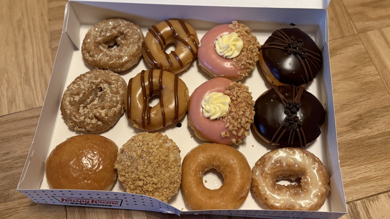 a box of Krispy Kreme Doughnuts on wooden surface