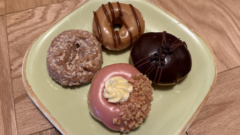 Four Krispy Kreme Winter Seasonal Doughnuts on a green, square plate