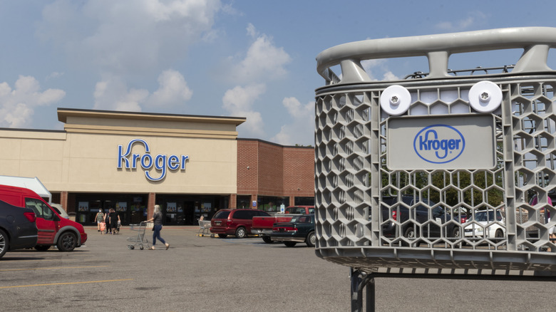 View of Kroger store facade from the parking lot and a Kroger cart up close.