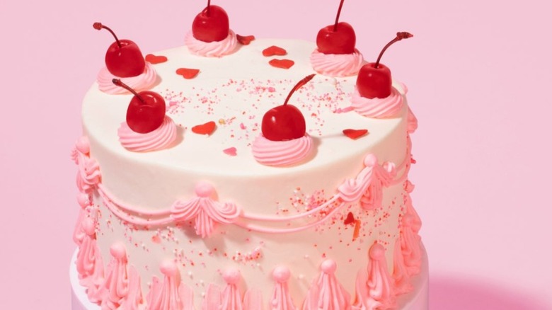 Goldbelly﻿ pink and white cake decorated with cherries on top