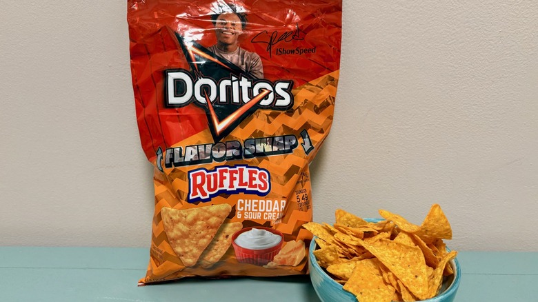 A bag and bowl filled with Flavor Swap Ruffles Cheddar & Sour Cream on Ruffles, with photo of influencer I Show Speed above Doritos logo on bag