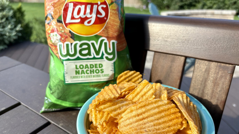 A bowl and bag of Lay's wavy loaded nachos flavor chips