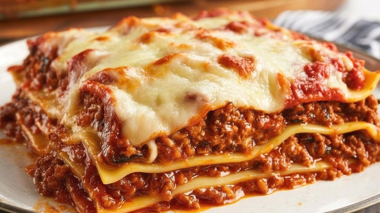 A close-up of a slice of lasagna sitting on a plate.
