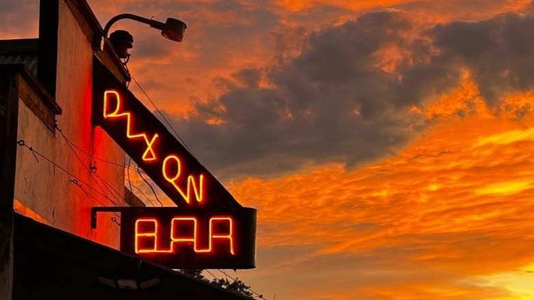 Neon Dixon Bar sign against an orange sunset