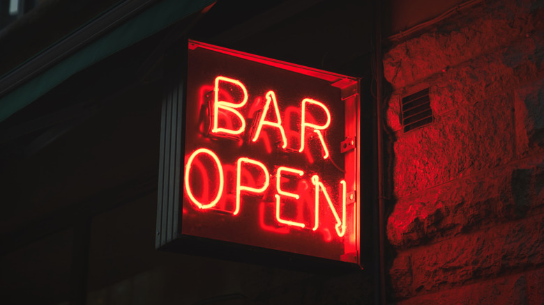 Neon red Bar Open sign on stone building