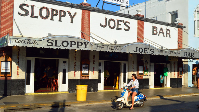 A girl on a cooter in front of Sloppy Joe's Bar