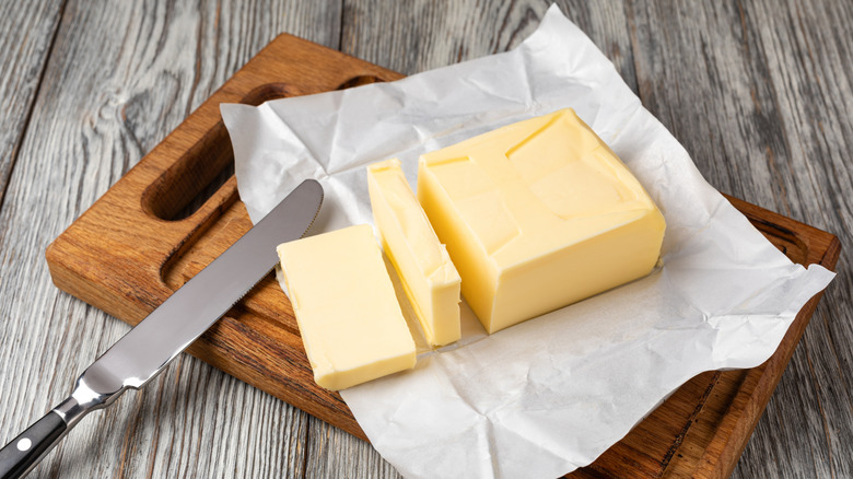 A block of butter that has been sliced with a butter knife