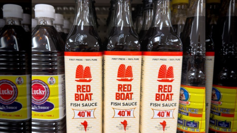 Bottles of fish sauce on a supermarket shelf.