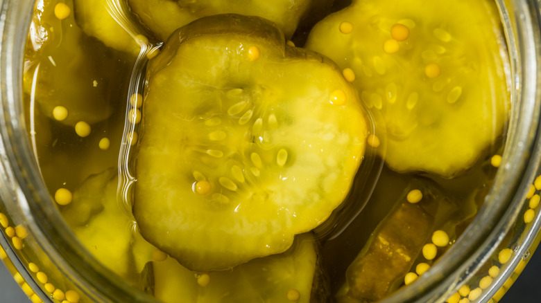 Close-up of jarred dill pickles, sliced