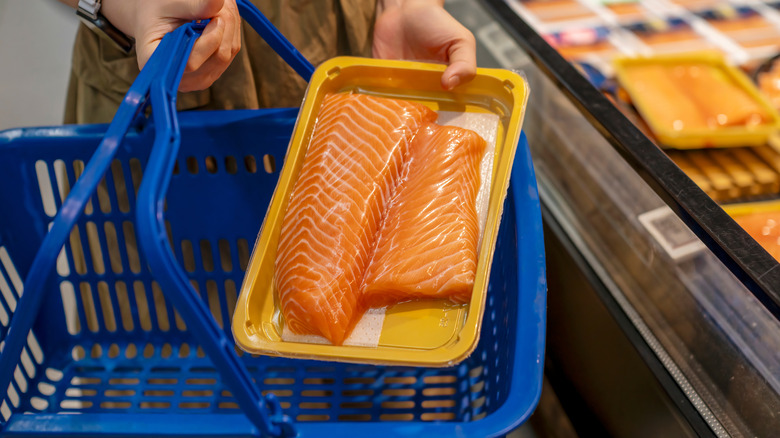 Salmon fillet being placed into a shopping basket