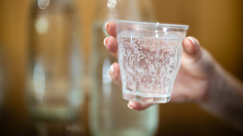 Glass of sparkling or still water, soda, or mineral water.