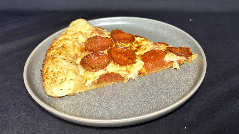 A slice of pepperoni pizza on a gray plate