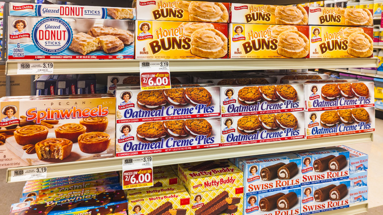 A grocery store shelf stocked with Little Debbie snacks
