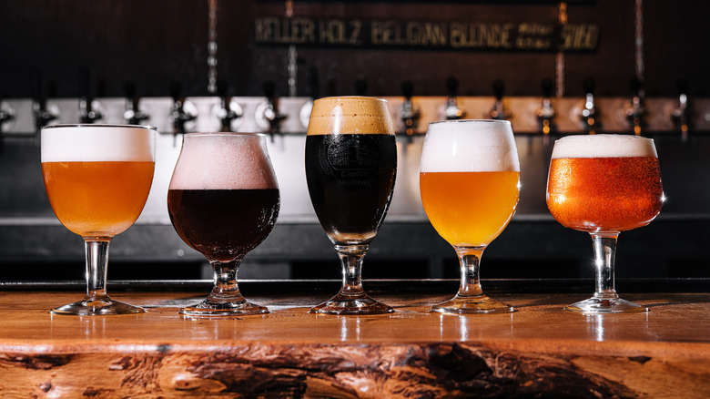 Several craft beers of different types on a rustic wooden bar