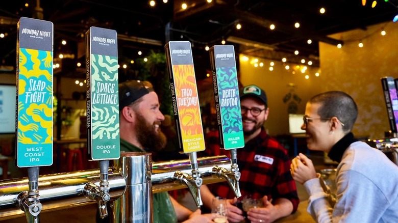 View of a taproom from behind the bar, where people are talking and drinking