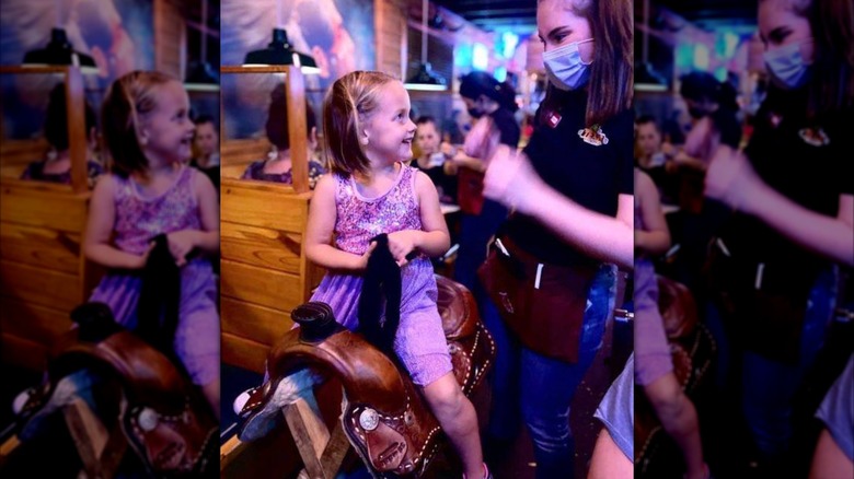 Girl on the Texas Roadhouse birthday saddle
