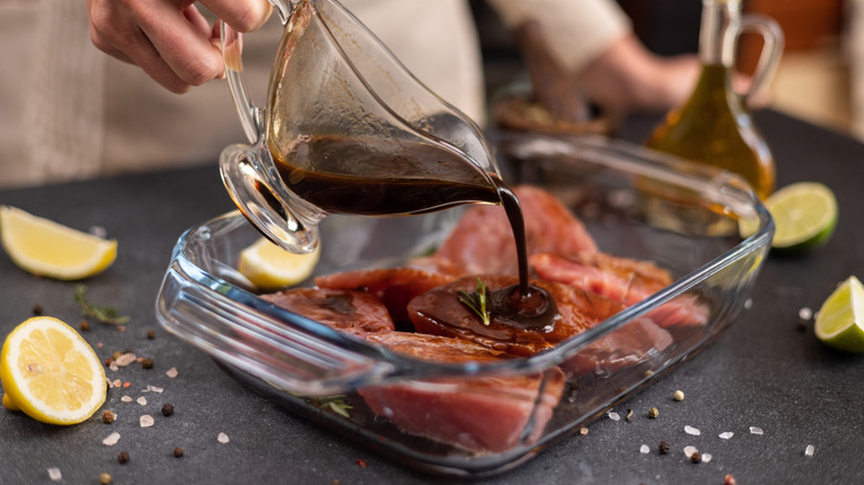 Pouring marinade on steaks