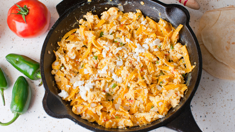 Cast iron pan with scrambled egg and tortilla chip migas