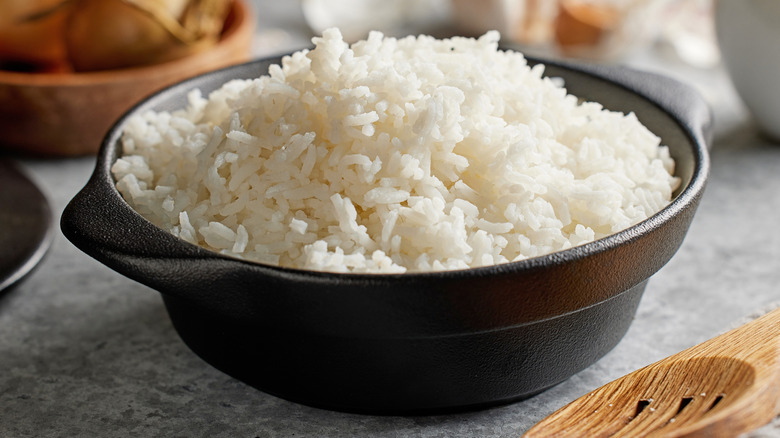 Bowl of cooked white rice  in a small black pot