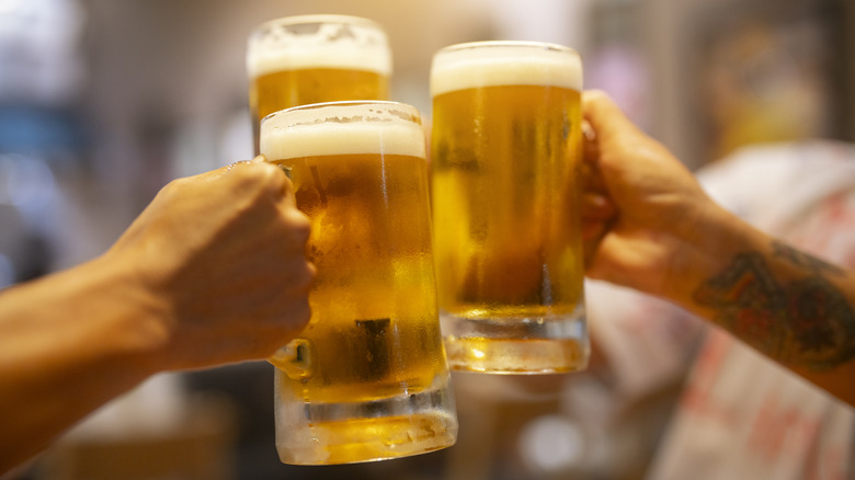 Hands toasting beer glasses