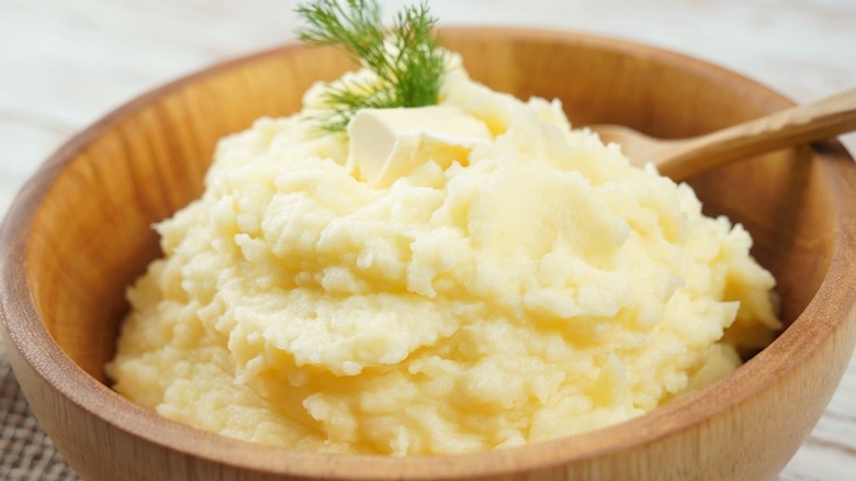 A wooden bowl of mashed potatoes.