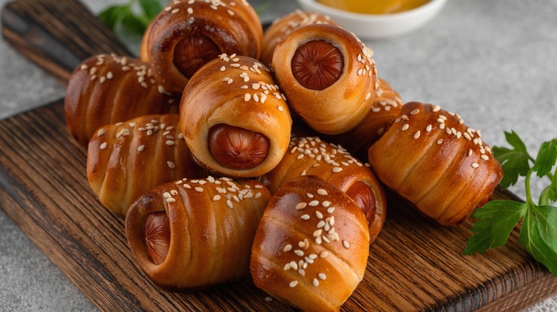 Pigs in a blanket on wood board