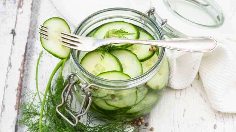 Top view of a jar of fresh sliced cucumber quick pickles