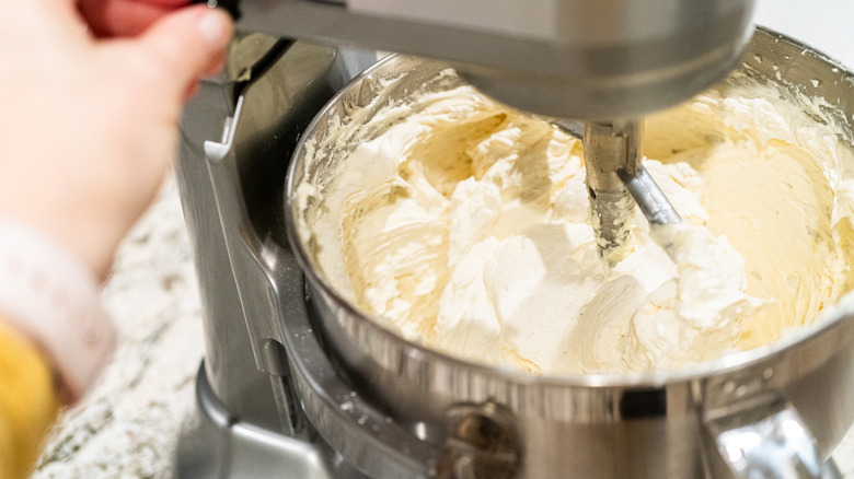 White frosting being whipped in a stand mixer